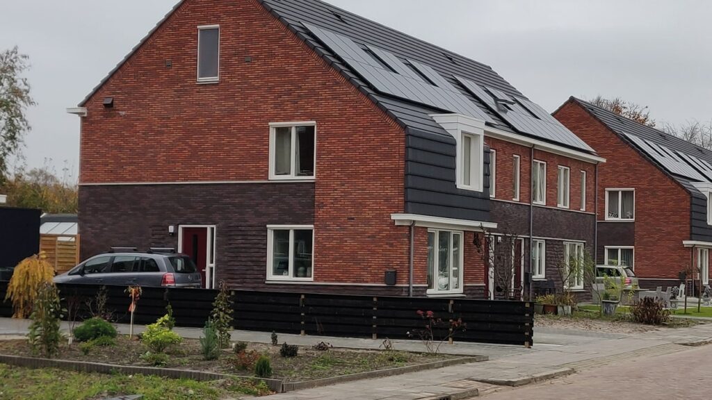 Modernes Backsteinhaus von außen mit Solarpanels auf dem Dach